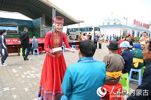 鄂尔多斯乌兰木骑队员在母亲节为乌审旗黄陶勒盖嘎查村民分发法治宣传手册。鄂尔多斯市乌兰牧骑供图